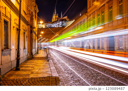 Letenska Street glows at night as light trails from trams create a dynamic view. Prague Castle looms in the background, showcasing the beauty of Lesser Town. 123089487
