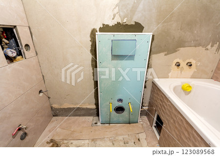 Unfinished reconstruction of bathroom or toilet with ceramic tiles installed on walls of drywall, place for lavatory and bath. 123089568