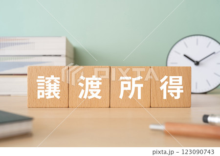 譲渡所得の文字が入ったブロックが置かれたデスク 123090743