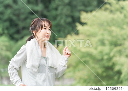 ダイエット・カロリー消費のため公園でウォーキング・運動をするスポーツウェアのアジア人女性 ダイエット・カロリー消費のため公園でウォーキング・運動をするスポーツウェアのアジア人女性 123092464