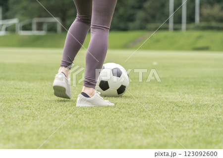 サッカー場でユニフォームを着てサッカー・フットサルの練習をする日本人女性 サッカー場でユニフォームを着てサッカー・フットサルの練習をする日本人女性 123092600