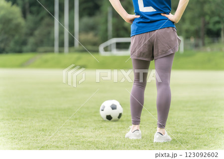 サッカー場でユニフォームを着てサッカー・フットサルの練習をする日本人女性 サッカー場でユニフォームを着てサッカー・フットサルの練習をする日本人女性 123092602