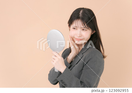 鏡を見るスーツの女性 123092955