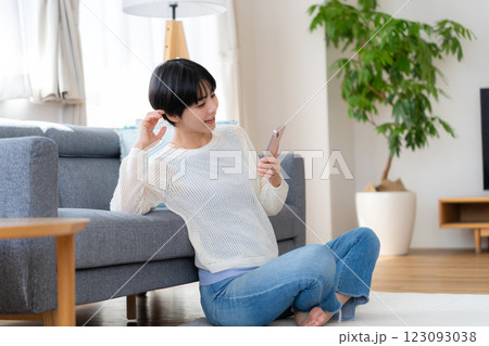 部屋でスマホを操作する女性 部屋でスマホを操作する女性 123093038