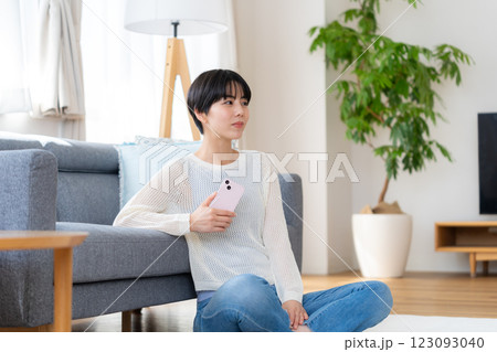 部屋でスマホを操作する女性 123093040