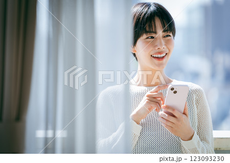 部屋でスマホを操作する女性 123093230