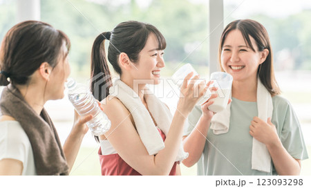 スポーツジムのヨガ教室で休憩をしながらプロテインや水を飲むする女性達 123093298