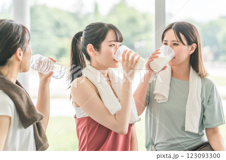 スポーツジムのヨガ教室で休憩をしながらプロテインや水を飲むする女性達 123093300