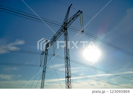 Steel pillar with high voltage electric power lines delivering electrical energy through cable wires on long distance 123093869