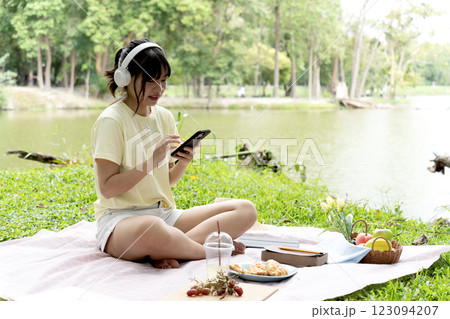 teenage girl is sitting happily relaxing and listening to music with headphones 123094207