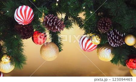 A beautifully decorated Christmas garland with red, gold ornaments, and pinecones. Ideal for holiday-themed designs and festive decorations A beautifully decorated Christmas garland with red, gold ornaments, and pinecones. Ideal for holiday-themed designs and festive decorations 123094465