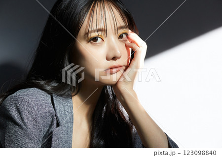 ジャケットを着た若い女性の陰影のある雰囲気のあるポートレート 123098840