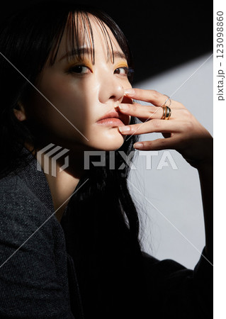 ジャケットを着た若い女性の陰影のある雰囲気のあるポートレート 123098860