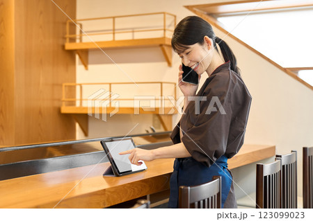 タブレットで管理をする飲食店の従業員 タブレットで管理をする飲食店の従業員 123099023