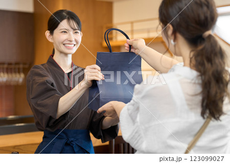 商品を渡す飲食店の従業員 123099027