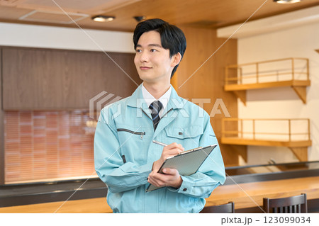 飲食店で点検をする作業着を着た男性 飲食店で点検をする作業着を着た男性 123099034