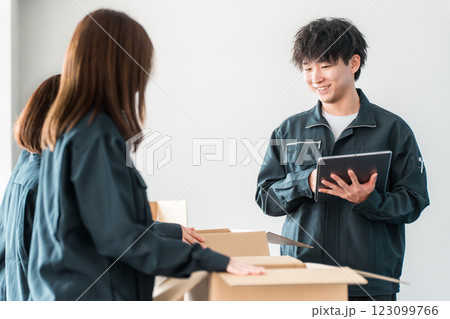 ダンボールに荷物を詰める運送・物流・宅急便・宅配便・流通・配達・宅配業者の作業員 123099766