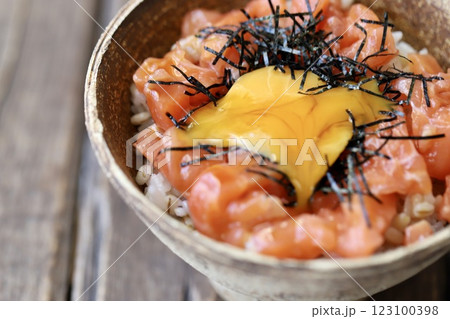 卵黄を崩したサーモンユッケ丼 123100398