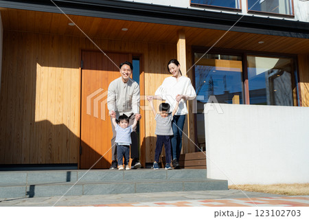 マイホームの前で記念撮影をする4人家族 123102703
