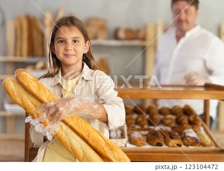 Girl in bakery chooses bread, considers various product options. 123104472
