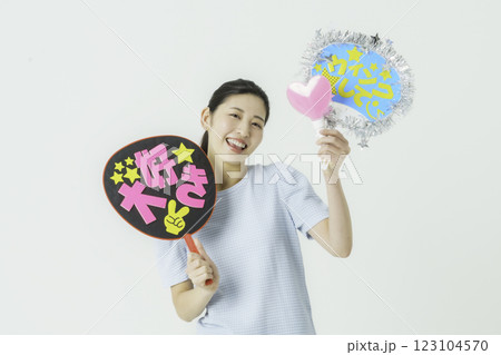 推し活　白背景のうちわを持って推しを応援する若い女性 123104570