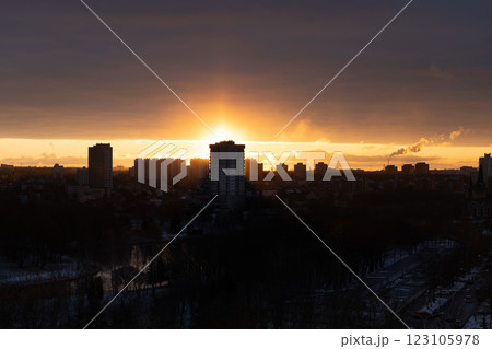 The rising sun is blocking a tall, residential building. Dawn in the city 123105978
