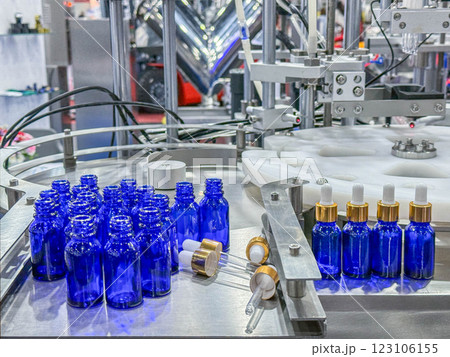 Glass bottles in a conveyor belt on a high quality automatic vertical filling machine. In the factory production line 123106155