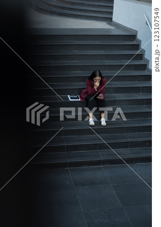 Depressed businesswoman sits on stairs outside office, overwhelmed by financial crisis, job loss, and stress. failure, burnout, and workplace pressure. Depressed businesswoman sits on stairs outside office, overwhelmed by financial crisis, job loss, and stress. failure, burnout, and workplace pressure. 123107549