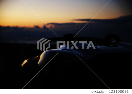 夕暮れの黒いオープンカー 123108051