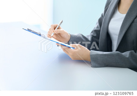 アンケートに答えるクリップボードを持った若い女性のパーツカット撮影協力:スカパー東京メディアセンター 123109765