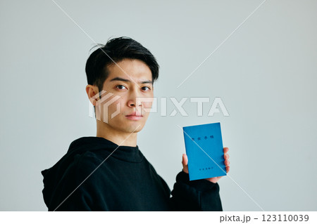 年金手帳を持つ20代の若い男性 123110039