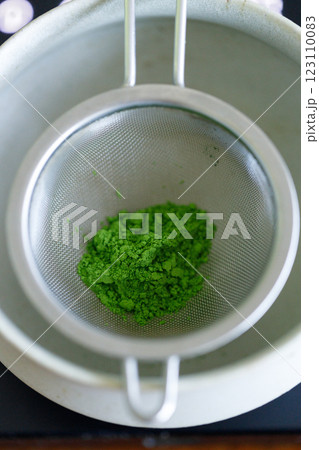 Closeup of fresh matcha powder, green tea powder, Chashaku, matcha scoop and Chawan, matcha bowl. 123110083