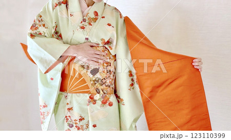 朱色の帯を肩から垂らす着付け途中の女性_ワイド 朱色の帯を肩から垂らす着付け途中の女性_ワイド 123110399