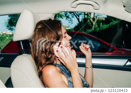 Joyful young caucasian female talking on phone in car parked on a sunny day 123110415
