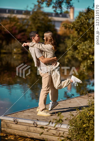 A happy couple in love in casual clothes travel together, hike and have fun in the fall forest on a weekend in nature in autumn outdoors, selective focus. COUPLE LOVE STORY park pond lake. Handsome 123110570
