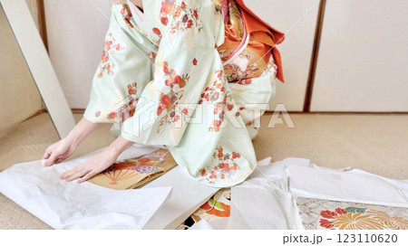 着物を着て帯をたとう紙に包む女性_ワイド 123110620