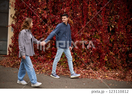 Young Cute Female Hugs Boyfriend. In Autumn Outdoor. Lovers Walking in Park. Attractive Funny Couple. Lovestory in Forest. Man and Woman. Cute Lovers in the Park. Family Concept. Happy Couple. 123110812