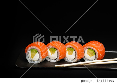 Delicious Fresh Salmon Sushi Rolls Presenting Exquisitely on a Black Background Delicious Fresh Salmon Sushi Rolls Presenting Exquisitely on a Black Background 123111493