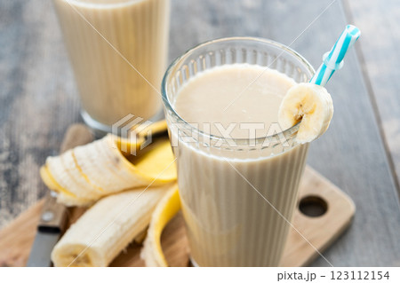 Fresh banana smoothie on white wooden table. 123112154