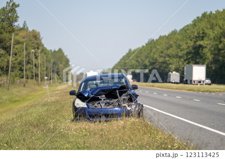 Old crashed car abandoned on highway road shoulder. Damaged in traffic accident vehicle parked on roadside 123113425