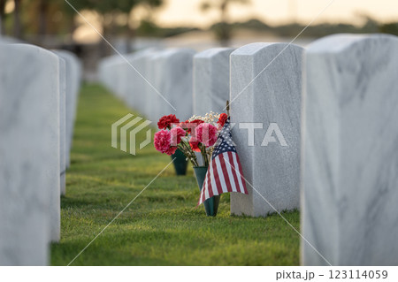 Military burial headstones. Sarasota National Cemetery with rows of white tomb stones with flowers and USA flags on green grass. Memorial Day concept Military burial headstones. Sarasota National Cemetery with rows of white tomb stones with flowers and USA flags on green grass. Memorial Day concept 123114059
