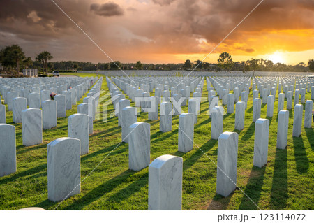 Memorial Day concept. Sarasota National Cemetery with rows of white tomb stones on green grass at sunset Memorial Day concept. Sarasota National Cemetery with rows of white tomb stones on green grass at sunset 123114072
