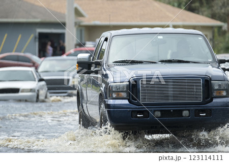Hurricane flooded street with moving cars and surrounded with water houses in Florida residential area. Consequences of natural disaster 123114111