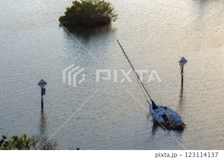 Half sunken sailing yacht capsized on shallow bay waters after hurricane Ian in Manasota, Florida Half sunken sailing yacht capsized on shallow bay waters after hurricane Ian in Manasota, Florida 123114137