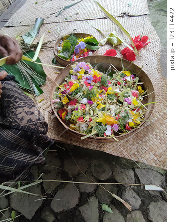 Traditional balinese offerings to gods in Bali with flowers and aromatic sticks Traditional balinese offerings to gods in Bali with flowers and aromatic sticks 123114422