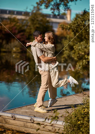 A guy carrying a girl on his back, at the beach, outdoors. River. Young Girl And Guy Love. Handsome young man kissing his girlfriend near the river A guy carrying a girl on his back, at the beach, outdoors. River. Young Girl And Guy Love. Handsome young man kissing his girlfriend near the river 123115048