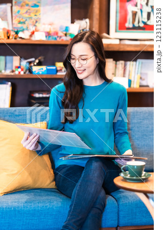 コーヒーを飲みながらレコードを手にする若い女性 123115238