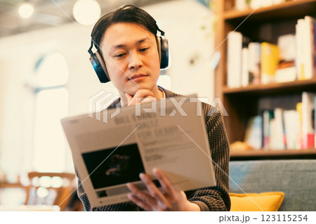 レコードをヘッドフォンで試し聞きするミドル男性 123115254