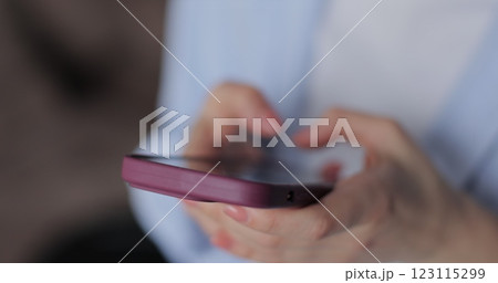 Close-up young woman using smartphone in living room at home. Girl using texting mobile phone or chat. Chatting on social networks online. Close-up young woman using smartphone in living room at home. Girl using texting mobile phone or chat. Chatting on social networks online. 123115299