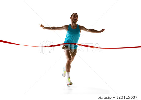 Dynamic photo of athlete crossing finish line, arms open and face filled with victory against white studio background. 123115687
